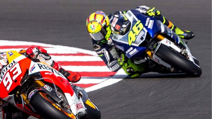 Due moto in piega: piloti n°93 e n°46 in lotta in curva su circuito MotoGP