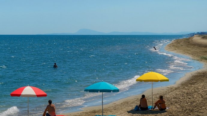 Spiaggia di Torrette Fano con tre ombrelloni colorati e pochi bagnanti sul litorale