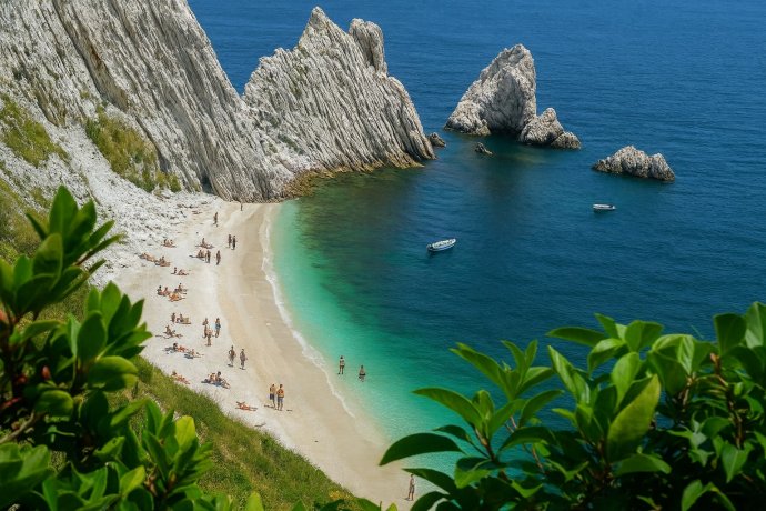 Spiaggia delle Due Sorelle a Sirolo: mare turchese, falesie bianche, due barche al largo.