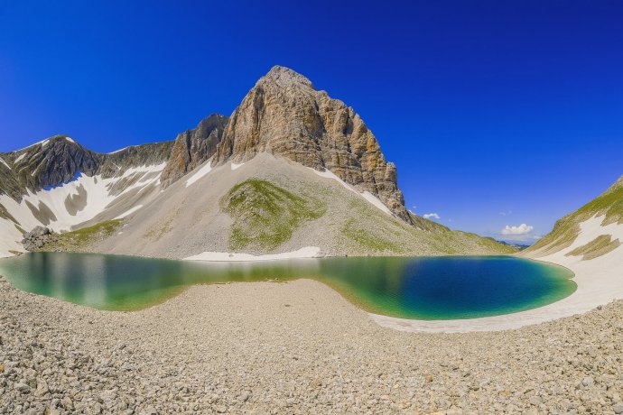 Lago di Pilato turchese sotto il Monte Vettore nei Sibillini, bacino glaciale a occhio di bue