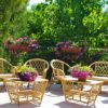 Terrazza con mobili in rattan e piante fiorite.