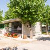 Bungalow con fiori in vaso e alberi intorno.