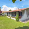 Casa con tetto rosso, giardino e piante fiorite.