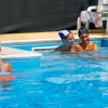Persone con cuffie nuotano in piscina. Una sotto una cascata.