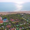 Vista aerea di un campeggio con piscina vicino alla spiaggia.