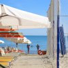Spiaggia con ombrelloni e rete da beach volley vicino al mare.