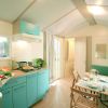 Interno di una cucina moderna con mobili turchesi e un tavolo apparecchiato.