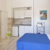 Monolocale con letto, angolo cottura e tavolo, arredamento semplice.