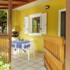 Veranda con tavolo apparecchiato e sedie bianche.