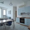 Cucina moderna con mobili azzurri, tavolo e sedie blu scure.