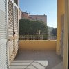 Balcone con pavimento piastrellato, ringhiera in metallo e vista su altre abitazioni.
