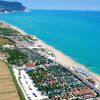 Veduta aerea di una spiaggia con acque turchesi e un resort vicino alla costa.