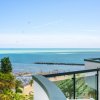 Vista mare da un balcone, con spiaggia e ombrelloni.