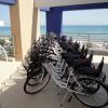 Biciclette allineate su una terrazza con vista sul mare.