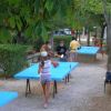 Persone che giocano a ping pong su tavoli all'aperto.