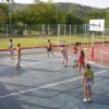 Persone giocano a pallavolo su un campo all'aperto.