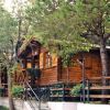 Una casa di legno circondata da alberi e fiori.