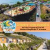 Water park e bungalow con palme vicino al mare. Scritta promozionale sovrapposta.
