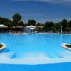 Ampia piscina esterna con isole erbose e bagnanti.